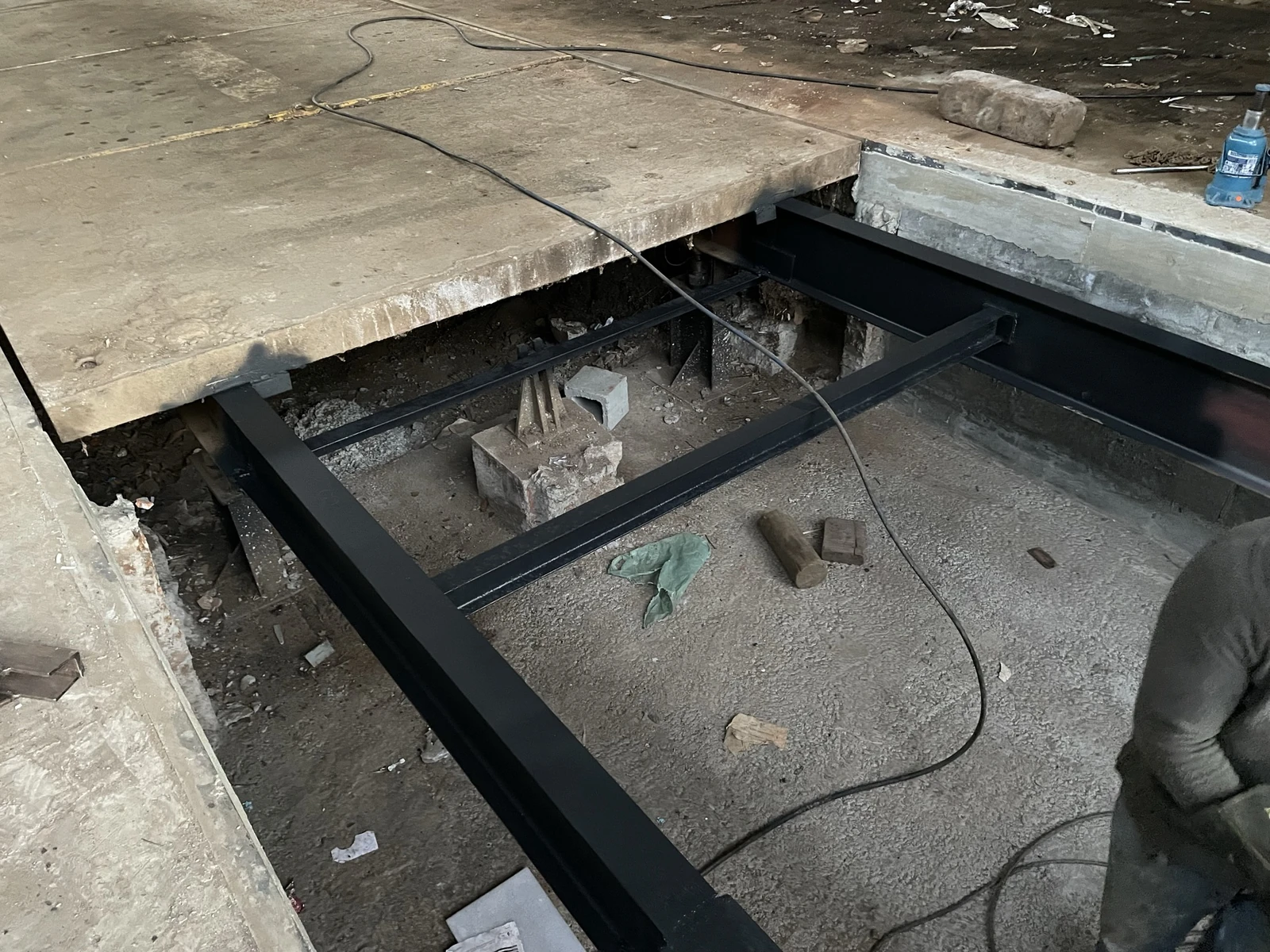 Estrutura metálica nova do prolongamento de uma balança rodoviária, ao lado da plataforma de concreto existente