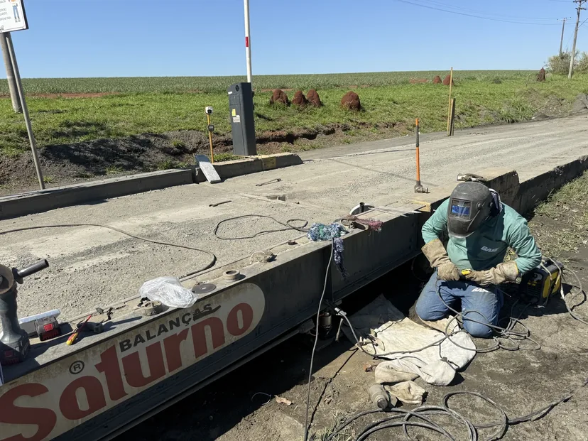 Técnico realizando reparo na estrutura de uma balança