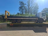 Caminhão sobre uma balança rodoviária BRMC instalada, com a marca JNL na lateral da balança
