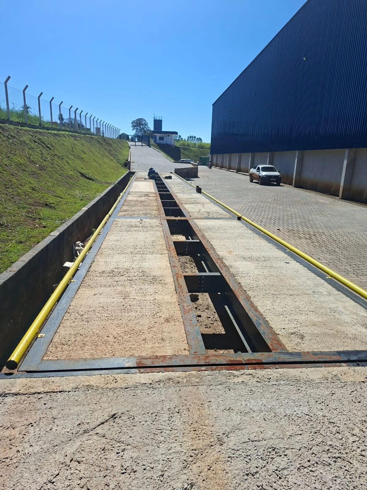Pista de balança rodoviária JNL ao lado de um galpão