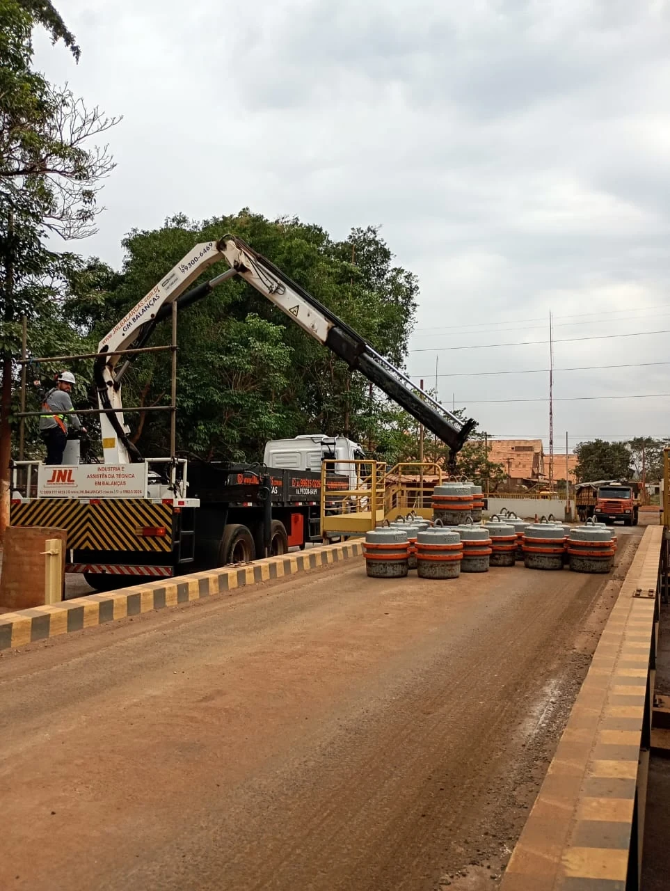 Calibração de balança rodoviária com pesos padrão e caminhão com guindaste